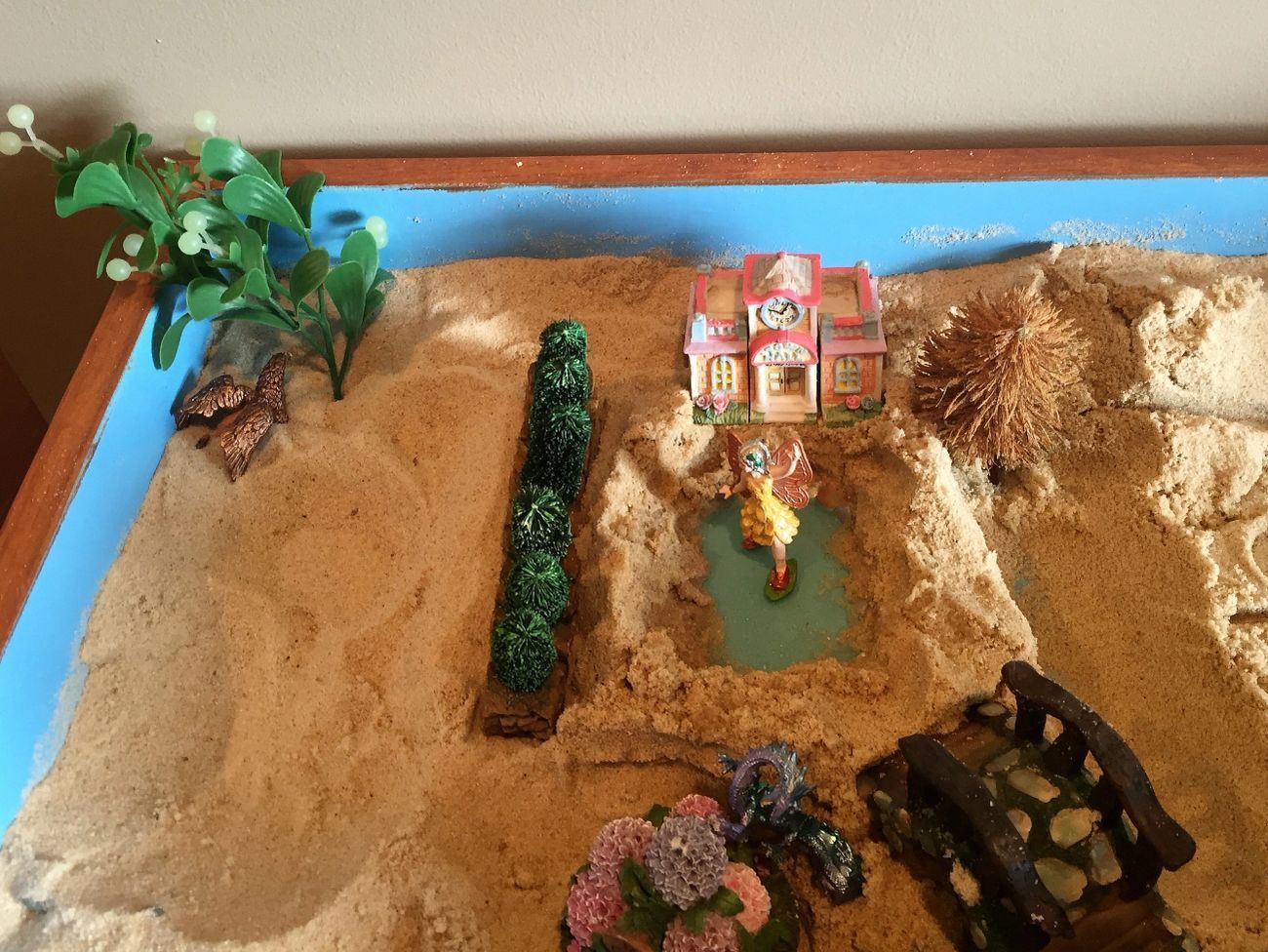 A sand table with plants and buildings in it