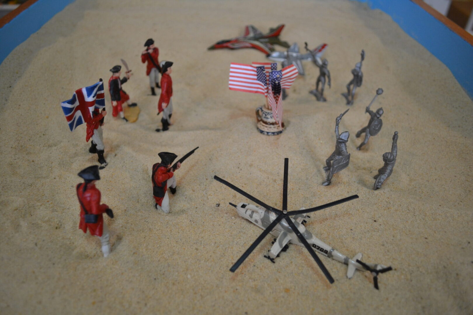 A group of toy soldiers on the sand.